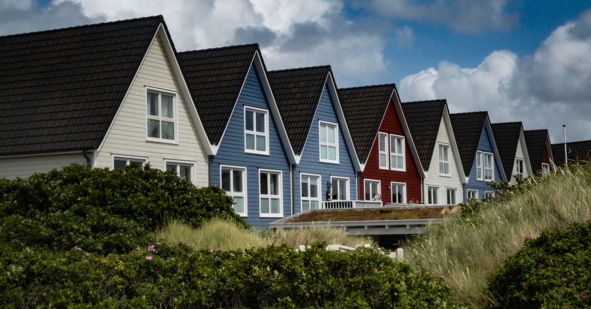 Charming Nordic row houses by the coast under a cloudy sky, highlighting traditional Scandinavian architecture.